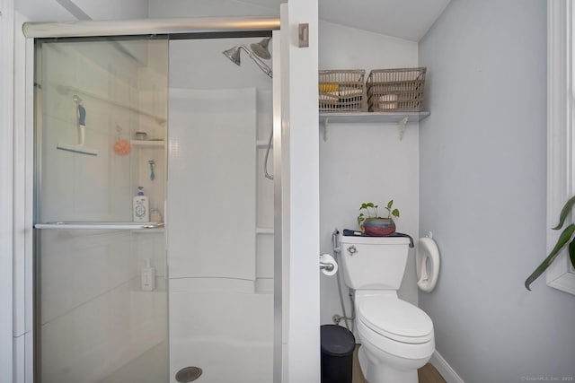 bathroom featuring toilet and a stall shower