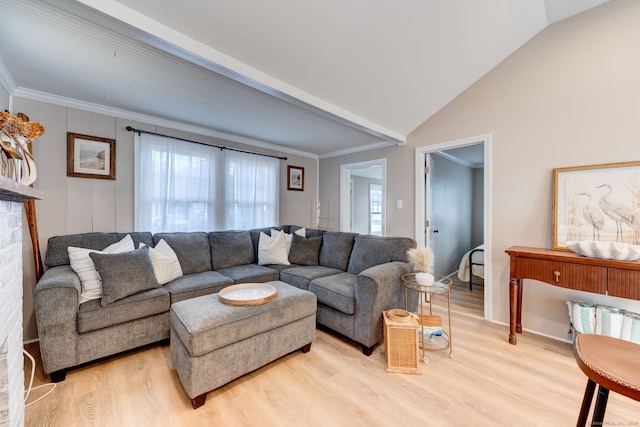 living room featuring vaulted ceiling, ornamental molding, and light wood-style floors