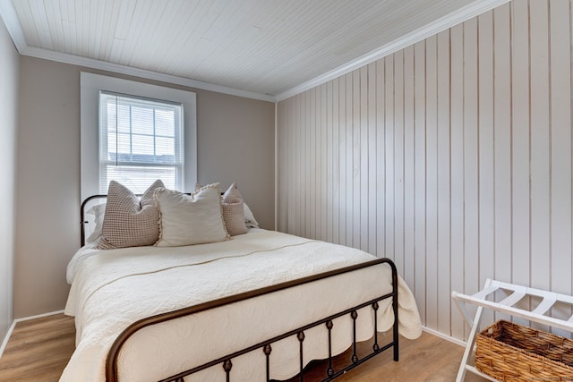 bedroom featuring ornamental molding and light wood finished floors