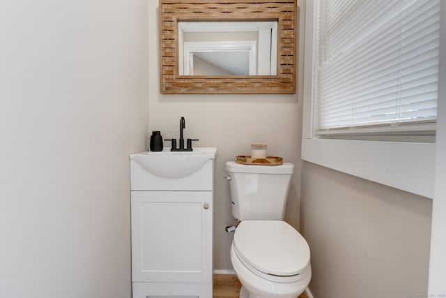 half bathroom featuring vanity and toilet