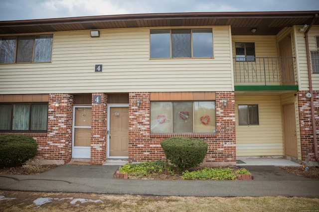 multi unit property featuring brick siding and a balcony