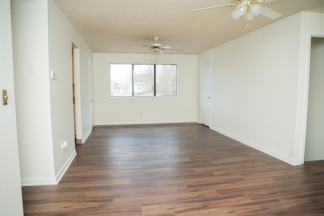 spare room featuring dark wood-style floors, baseboards, a ceiling fan, and a textured ceiling