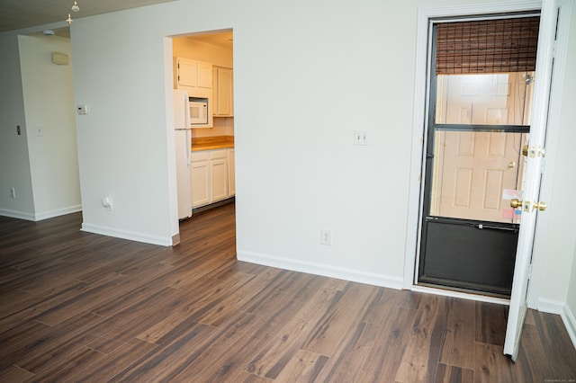 unfurnished room with baseboards and dark wood-style flooring