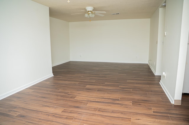 spare room featuring baseboards, wood finished floors, visible vents, and a ceiling fan