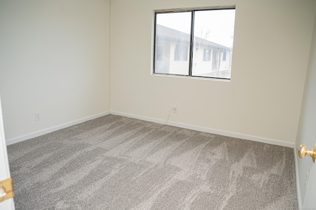 spare room featuring carpet floors and baseboards