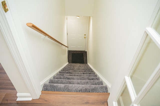 staircase with wood finished floors and baseboards