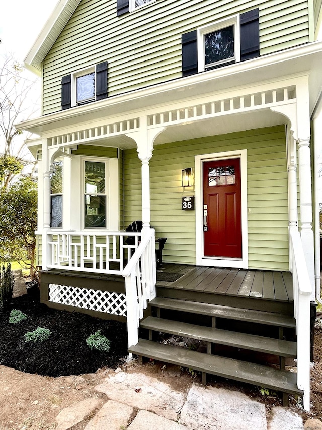 doorway to property with a porch and a standing seam roof