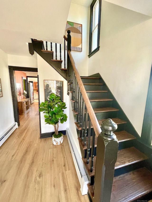 staircase featuring a baseboard radiator and wood finished floors