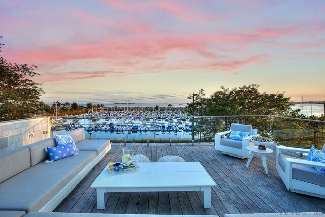 wooden terrace featuring outdoor lounge area and a water view