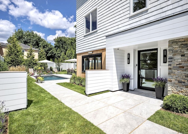 view of yard with a patio area, fence, and an outdoor pool