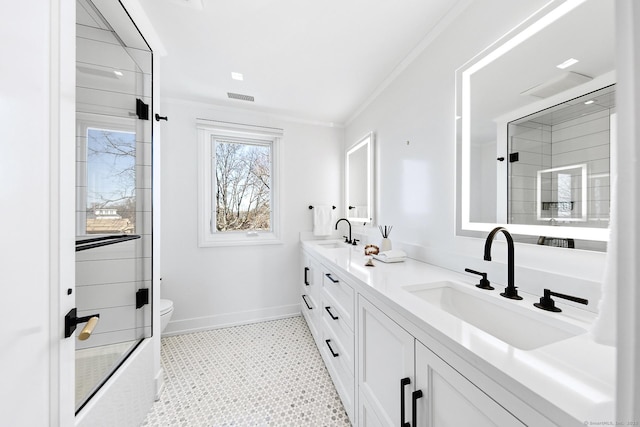 bathroom featuring double vanity, visible vents, ornamental molding, a shower with shower door, and a sink