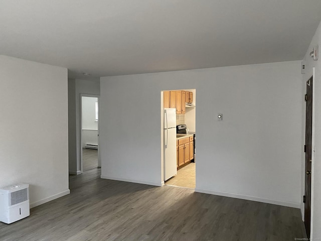 spare room with light wood-type flooring, baseboards, and baseboard heating