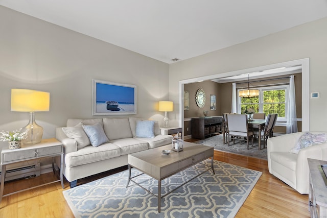 3 Spencer Ct, Clinton, CT 06413 - living room with wood finished floors, baseboard heating, and a chandelier