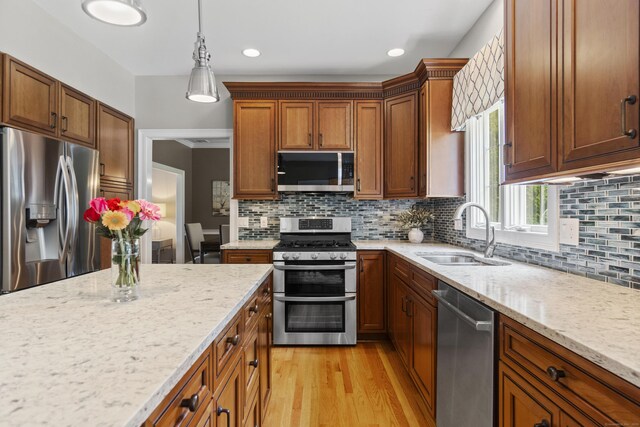3 Spencer Ct, Clinton, CT 06413 - kitchen with appliances with stainless steel finishes, a sink, light stone countertops, decorative light fixtures, and light wood-style flooring