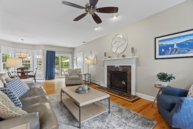 3 Spencer Ct, Clinton, CT 06413 - living room featuring a fireplace, baseboard heating, wood finished floors, and a ceiling fan
