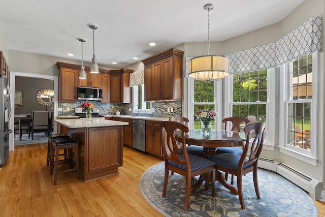 3 Spencer Ct, Clinton, CT 06413 - kitchen featuring stainless steel appliances, backsplash, light wood-type flooring, a kitchen island, and decorative light fixtures