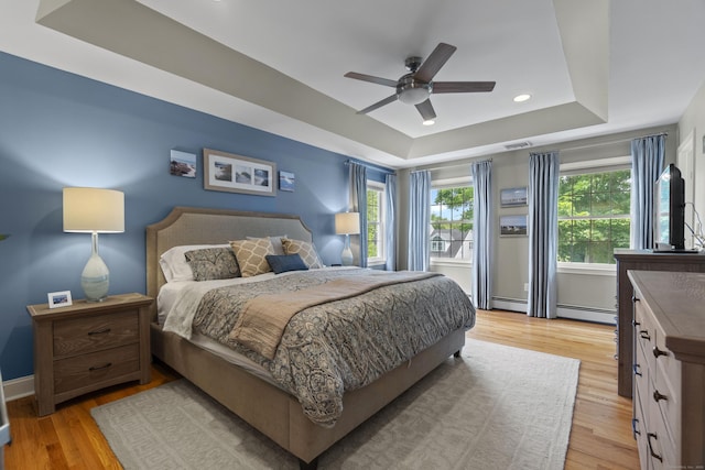 3 Spencer Ct, Clinton, CT 06413 - bedroom with a tray ceiling, baseboard heating, light wood-style floors, baseboards, and a ceiling fan