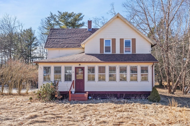 view of front of property with entry steps, a shingled roof, and a chimney