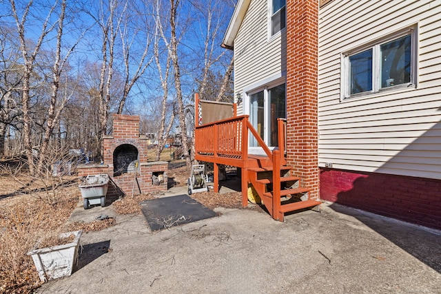 view of yard featuring an outdoor brick fireplace and a deck