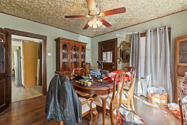 dining area with an ornate ceiling, crown molding, a ceiling fan, and dark wood-style flooring