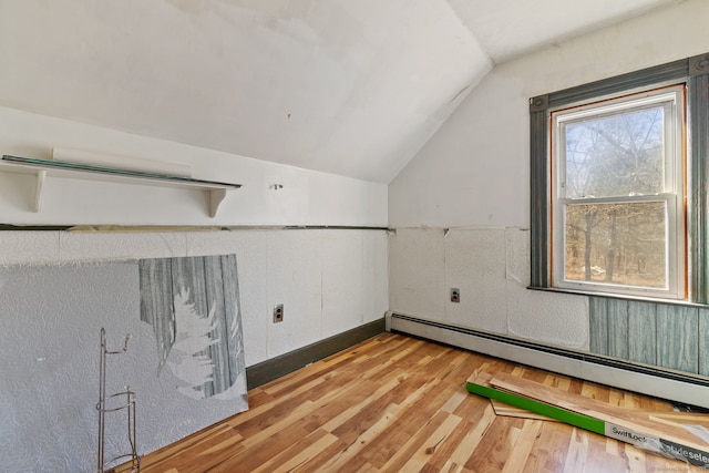 bonus room featuring a baseboard heating unit, vaulted ceiling, wainscoting, and wood finished floors