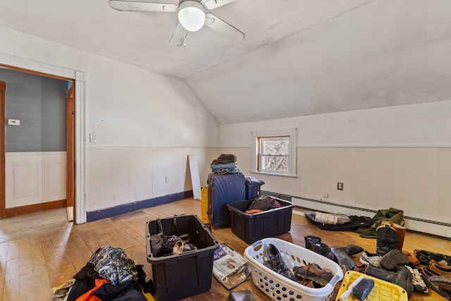 bonus room featuring lofted ceiling, hardwood / wood-style flooring, a ceiling fan, and wainscoting