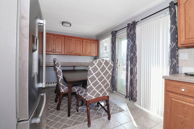 interior space featuring light countertops, light tile patterned floors, stainless steel fridge with ice dispenser, and tasteful backsplash