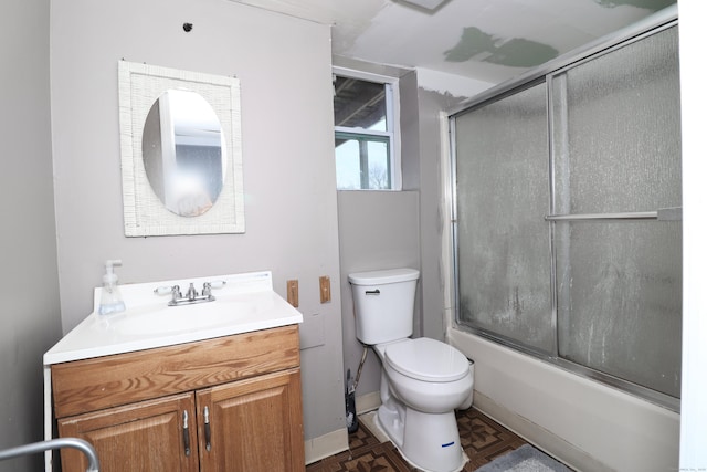 bathroom featuring vanity, toilet, baseboards, and enclosed tub / shower combo