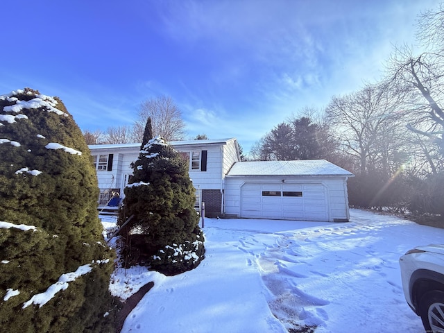 view of snowy exterior featuring a detached garage