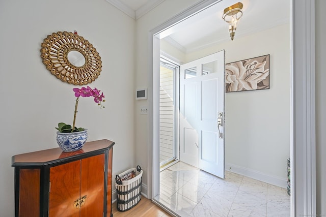 foyer with baseboards, marble finish floor, and ornamental molding