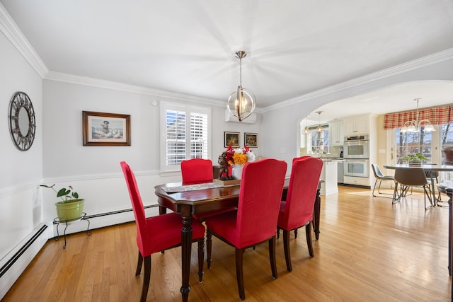 dining room with arched walkways, a notable chandelier, crown molding, and light wood finished floors