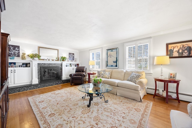 living room featuring a premium fireplace, a baseboard heating unit, crown molding, and wood finished floors