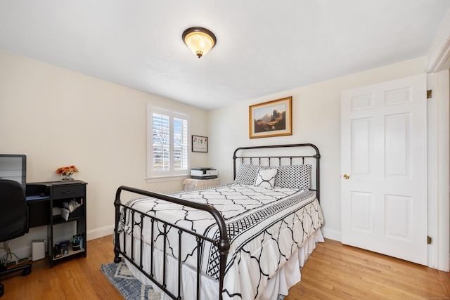 bedroom with wood finished floors and baseboards