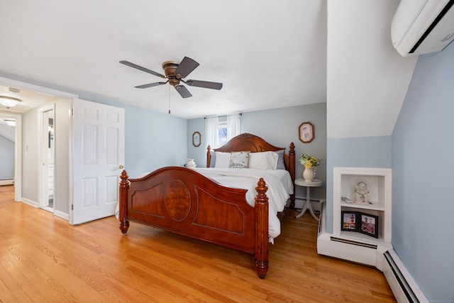 bedroom featuring a wall mounted air conditioner, a baseboard radiator, and light wood-type flooring