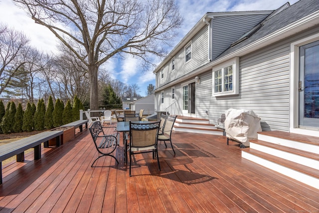 wooden deck featuring a grill, outdoor dining space, and entry steps