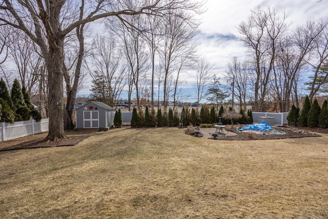 view of yard featuring an outdoor structure, a fenced backyard, and a shed