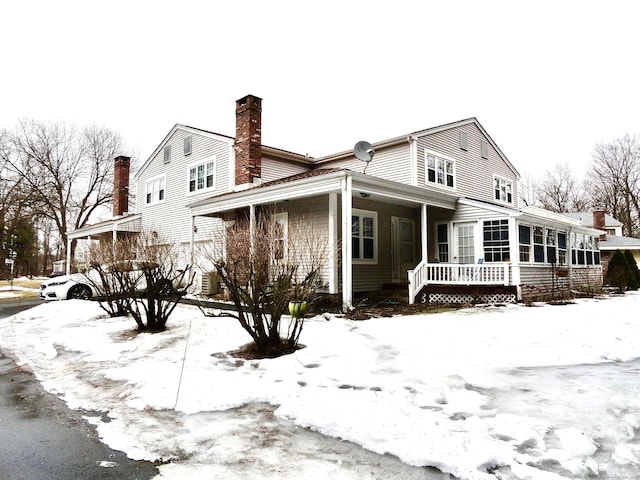 exterior space with a sunroom and a chimney