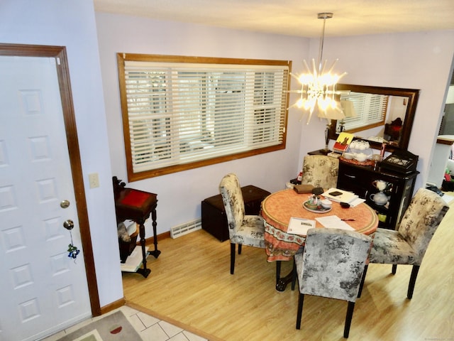 dining area with an inviting chandelier, baseboards, visible vents, and wood finished floors