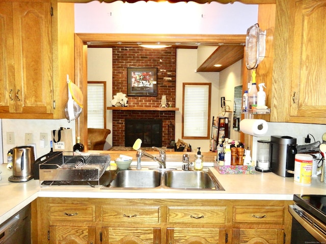 kitchen featuring a fireplace, light countertops, a sink, dishwasher, and a peninsula