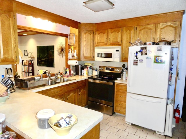 kitchen featuring brown cabinets, white appliances, and light countertops