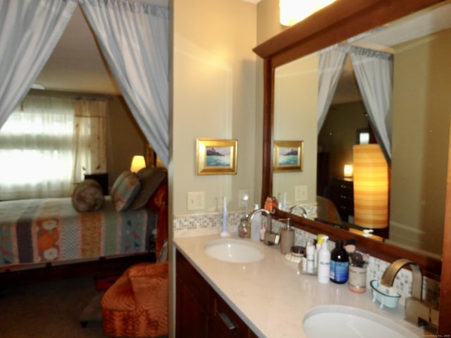 bathroom with a sink, ensuite bath, and double vanity