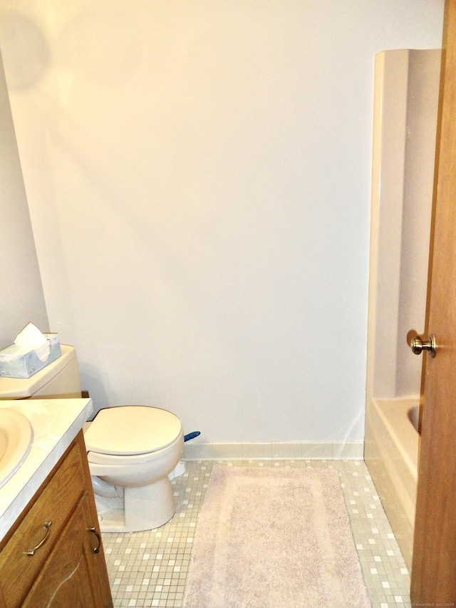 bathroom featuring a bathtub, toilet, vanity, tile patterned flooring, and baseboards