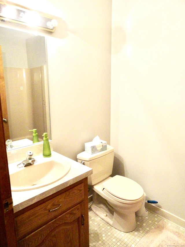 bathroom with tile patterned flooring, vanity, and toilet