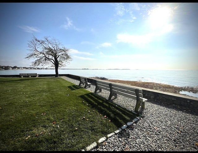 view of dock with a yard and a water view