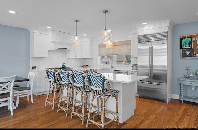 kitchen with appliances with stainless steel finishes, white cabinets, light countertops, and light wood-style floors