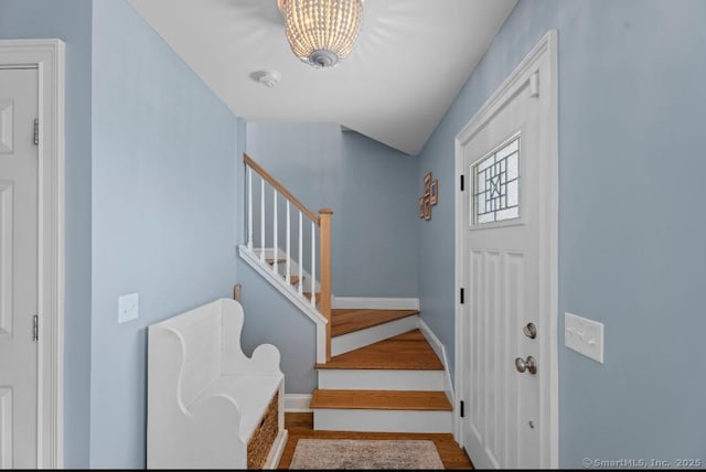 entrance foyer with stairs, wood finished floors, and baseboards