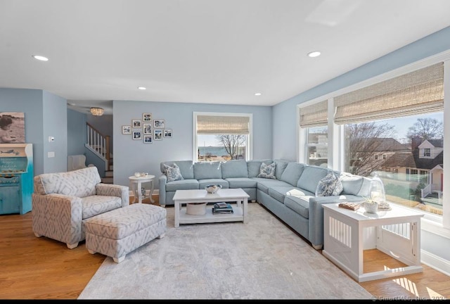 living room with recessed lighting, wood finished floors, baseboards, and stairs