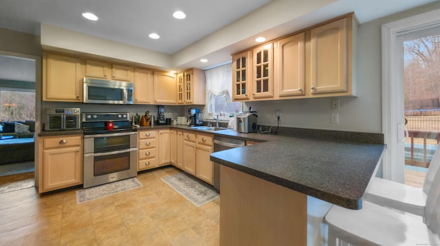 1557 Georges Hill Rd, Southbury, CT 06488 - kitchen featuring stainless steel appliances, dark countertops, a peninsula, glass insert cabinets, and light brown cabinets