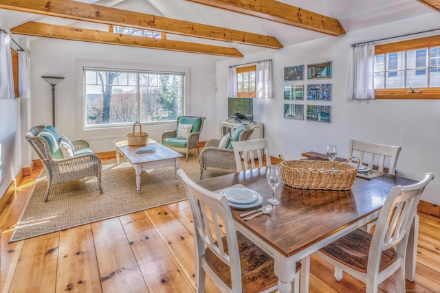 dining space with vaulted ceiling with beams and hardwood / wood-style flooring