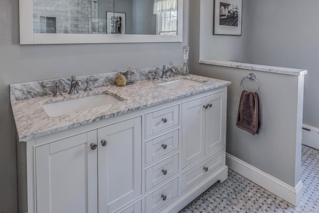 bathroom with double vanity, baseboards, and a sink